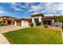 Inviting single-story home boasts a lush lawn, desert landscaping, and a three-car garage at 702 E Capricorn Way, Chandler, AZ 85249