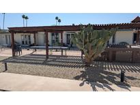 Exterior view of the home with a pergola and desert landscaping at 10039 W Lancaster Dr, Sun City, AZ 85351