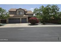 Two-story home with a three car garage, mature landscaping, and neutral colored paint at 12237 W Sherman St, Avondale, AZ 85323