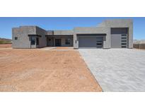 Stunning modern home with gray stucco and a three-car garage, and a paved driveway at 1250 E Smokehouse Trl, Phoenix, AZ 85085