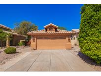 Beige two car garage and concrete driveway of home with tile roof under clear blue sky at 1744 E Boston Cir, Chandler, AZ 85225