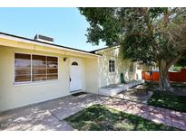 Home exterior featuring a mature tree, seating area, and convenient backyard access at 2614 W Greenway Rd, Tempe, AZ 85282