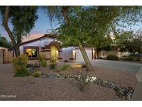 Charming single-story home featuring desert landscaping, an arched entryway, and warm exterior lighting at 263 S Del Rancho --, Mesa, AZ 85208