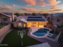 Sunset aerial view of the house highlighting a private pool and lush backyard with a basketball court at 29227 N 44Th St, Cave Creek, AZ 85331