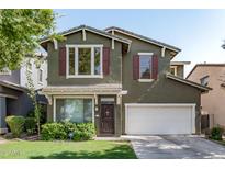 Charming two-story home featuring green exterior, red shutters, well-kept lawn and a two car garage at 4337 E Vaughn Ave, Gilbert, AZ 85234