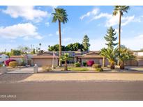 Charming ranch-style home with desert landscaping, mature palm trees, and an inviting front yard at 7240 W Grovers Ave, Glendale, AZ 85308