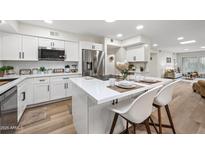 Bright kitchen features white cabinets, stainless steel appliances and an island with seating at 9120 N 86Th Way, Scottsdale, AZ 85258