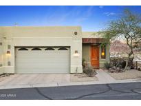 Inviting home featuring a two-car garage, desert landscaping, and an elegant wood entry door at 10005 N 1St Dr, Phoenix, AZ 85021