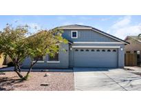 Charming single-story home featuring a two-car garage, desert landscaping, and a stylish mix of siding textures at 1399 E Anna Dr, Casa Grande, AZ 85122