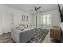 Bright living room boasts neutral tones, modern ceiling fan, plush seating, and access to a balcony at 2511 W Queen Creek Rd # 266, Chandler, AZ 85248