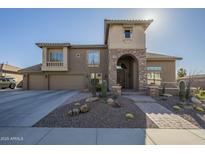 Inviting two-story home with stone accents, desert landscaping, and a spacious three-car garage at 27316 N Covered Wagon Rd, Phoenix, AZ 85085