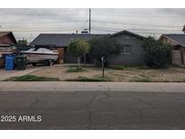 Modest single-story home showcasing its simple architectural details and mature landscaping in the front yard at 3025 N 53Rd Dr, Phoenix, AZ 85031