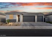 Charming single-story home with a three-car garage, desert landscaping, and a paver driveway at 3187 E Pineapple Rd, San Tan Valley, AZ 85143