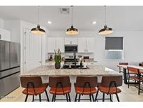 Bright kitchen features a large granite island with seating and modern pendant lighting above at 3187 E Pineapple Rd, San Tan Valley, AZ 85143