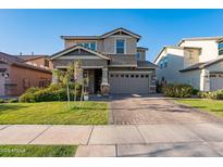 Two-story home with a well-manicured lawn, brick driveway and an attached two-car garage at 3828 E Pinto Dr, Gilbert, AZ 85296