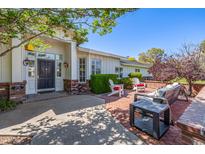 Inviting front entrance with a covered porch, brick accents, and comfortable seating area at 4030 N 54Th Pl, Phoenix, AZ 85018