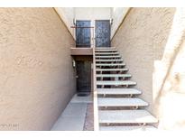 Exterior shot of a condo building with light colored stucco and front doors with wrought iron decoration at 4554 E Paradise Village N Pkwy # 210, Phoenix, AZ 85032