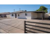 Charming single-story home featuring a covered carport, spacious driveway, and a decorative dark wood fence at 6130 N 27Th Ave, Phoenix, AZ 85017