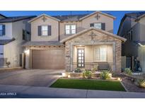 Charming two-story home featuring a brick facade, well-manicured landscaping, and a two-car garage at 634 E Deer Creek Rd, Phoenix, AZ 85048