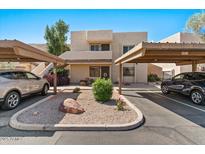 Tan two-story home featuring two carports, desert landscaping, and an inviting entrance at 7129 E Broadway Rd # 72, Mesa, AZ 85208