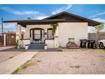 Charming home featuring a stucco exterior, covered porch, and low-maintenance gravel landscaping at 1505 W Fillmore St, Phoenix, AZ 85007