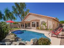 Inviting backyard pool with rock accents, lounge chairs, and covered patio, perfect for outdoor living at 18643 N 73Rd Ave, Glendale, AZ 85308
