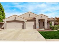 Charming home featuring a tile roof, three-car garage, and a well-manicured lawn at 2233 S Nielson St, Gilbert, AZ 85295