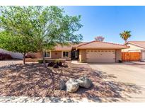 Charming single-story home featuring a two car garage, desert landscaping, and a red tile roof at 2753 E Kenwood St, Mesa, AZ 85213