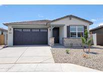 Charming single-story home showcasing stone accents, low-maintenance landscaping, and a two-car garage at 37069 W Prado St, Maricopa, AZ 85138