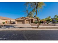 Charming home featuring a well-manicured front yard, desert landscaping, and a spacious three-car garage at 4356 E Carriage Way, Gilbert, AZ 85297