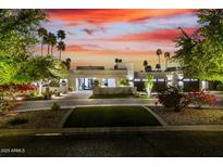 Stunning exterior elevation featuring lush landscaping, palm trees, and inviting curb appeal at twilight at 4835 E Onyx Ave, Paradise Valley, AZ 85253
