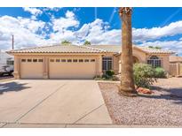 Charming beige home with a three-car garage, tile roof, and well-maintained landscaping at 530 N Jesse Ct, Chandler, AZ 85225