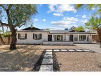 Charming single-story home featuring a white brick facade and well-manicured front yard with desert landscaping at 6271 E Evans Dr, Scottsdale, AZ 85254