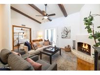 Inviting living room featuring beamed ceilings, a cozy fireplace, and stylish furnishings at 6526 N 13Th Dr, Phoenix, AZ 85013