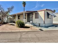 Charming mobile home with a covered porch, desert landscaping, and ample parking at 701 S Dobson Rd # 259, Mesa, AZ 85202