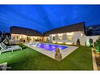 Backyard pool featuring lounge chairs, manicured lawn, and accent lighting for evening enjoyment at 87 W Windsor Ave, Phoenix, AZ 85003