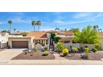 Charming home features a tile roof, desert landscaping, and gated front entrance at 9849 E Topaz Dr, Scottsdale, AZ 85258