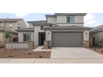 Charming two-story home with a neutral color scheme, tile roof, stone accents, and a spacious two-car garage at 17782 W Getty Dr, Goodyear, AZ 85338