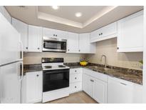 Well-lit kitchen with white cabinets, tile floors, and sleek countertops at 7920 E Camelback Rd # 303, Scottsdale, AZ 85251