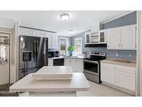 Kitchen with white cabinets, stainless steel appliances, and great lighting at 201 S Greenfield Rd # 51, Mesa, AZ 85206