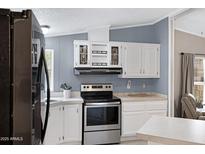 Charming kitchen with white cabinetry, stainless steel appliances, and plenty of counter space at 201 S Greenfield Rd # 51, Mesa, AZ 85206