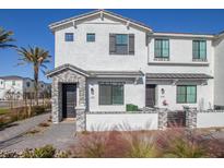 Stylish townhouse featuring a gray brick facade, white stucco, and a well-maintained front yard with desert landscaping at 669 E Scenic St, Apache Junction, AZ 85119