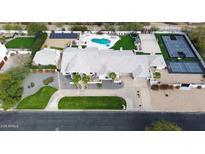 Expansive property featuring a pool, sports court, lush landscaping, and modern solar panels at 6718 E Caron Dr, Paradise Valley, AZ 85253