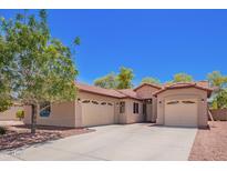 Charming home featuring a three car garage, desert landscaping, and a red tiled roof at 9259 W Caron Cir, Peoria, AZ 85345