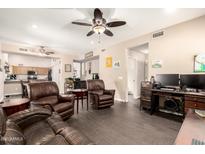 Spacious living room featuring comfortable leather seating and modern entertainment setup, bathed in natural light at 9646 N 94Th Ave, Peoria, AZ 85345