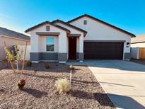 Charming single-story home featuring a two-car garage and low-maintenance desert landscaping at 11912 E Aster Ln, Florence, AZ 85132
