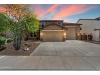 Charming home with a three-car garage, manicured landscaping, and a beautiful sunset backdrop at 12217 W Planada Ln, Sun City, AZ 85373