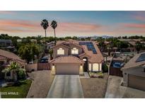Inviting two-story home boasting a red-tile roof, solar panels, and well-manicured landscaping for a desirable curb appeal at 12745 W Monte Vista Rd, Avondale, AZ 85392