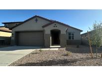 Charming single-story home with a two-car garage and low maintenance desert landscaping in the front yard at 25336 W Bowker St, Buckeye, AZ 85326