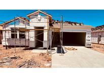 New home under construction showcasing the facade and roof tile installation, with a spacious garage and future landscaped yard at 30316 N Acacia Dr, Florence, AZ 85132